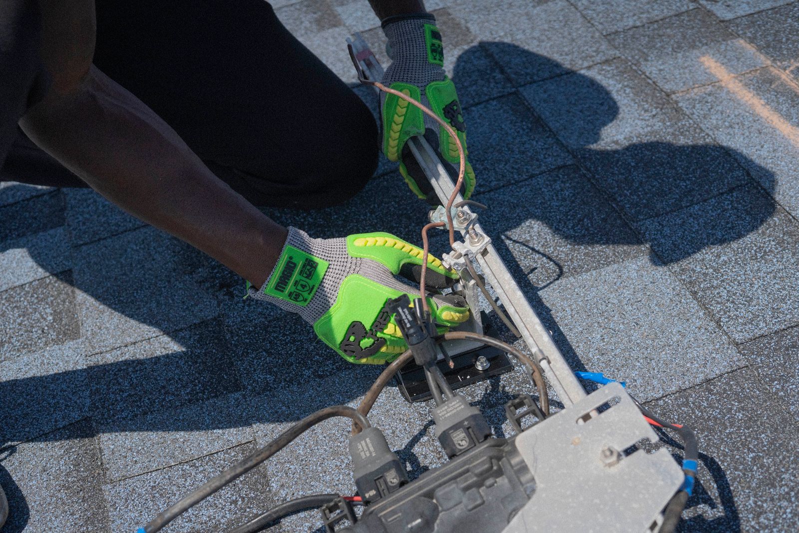 An electrician working inside an opened residential breaker panel