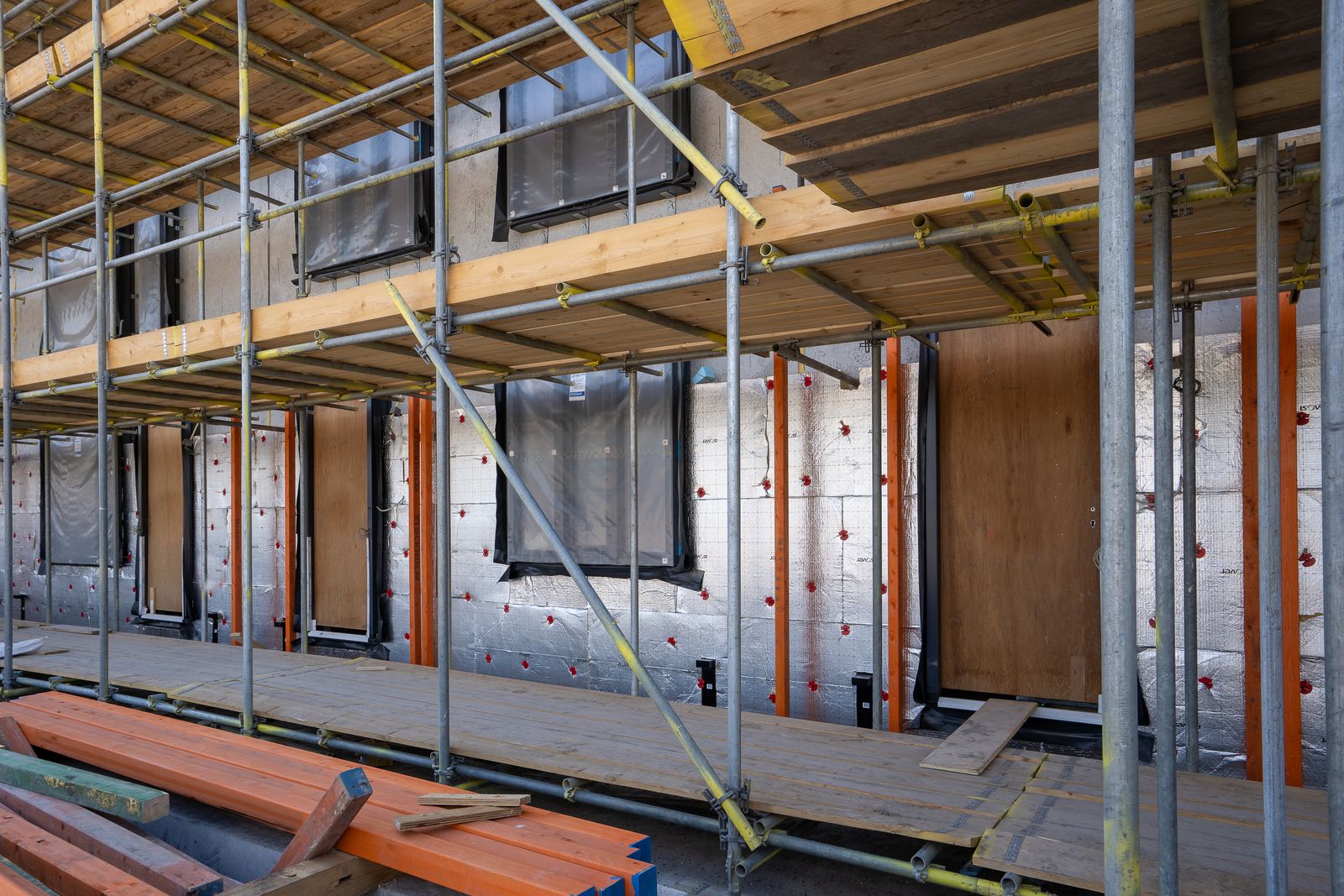 A new window unit being set into a wall opening